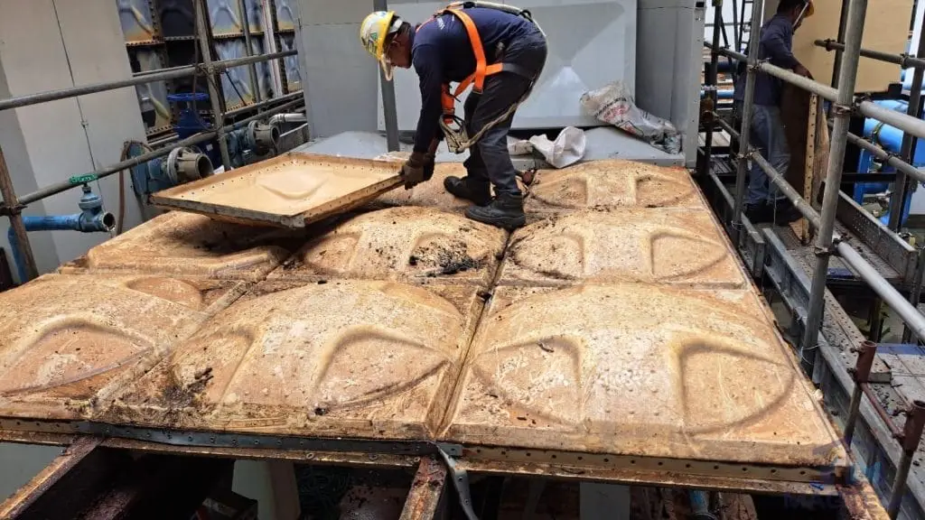 FRP/GRP domestic water tank replacement at One Finlayson Green, Singapore – worker dismantling the deteriorated existing tank panels