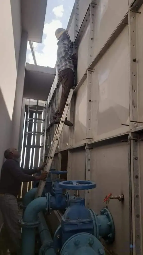 FRP water tank repair at Margaret Villa, Singapore – technician carrying out repair works beside the tank