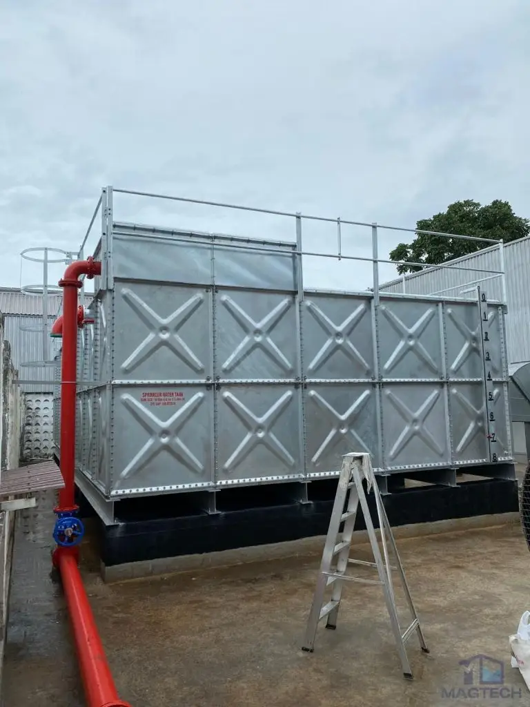 HDG pressed steel water tank installation at 188 Pandan Loop, Singapore – completed sectional tank connected to red external pipework