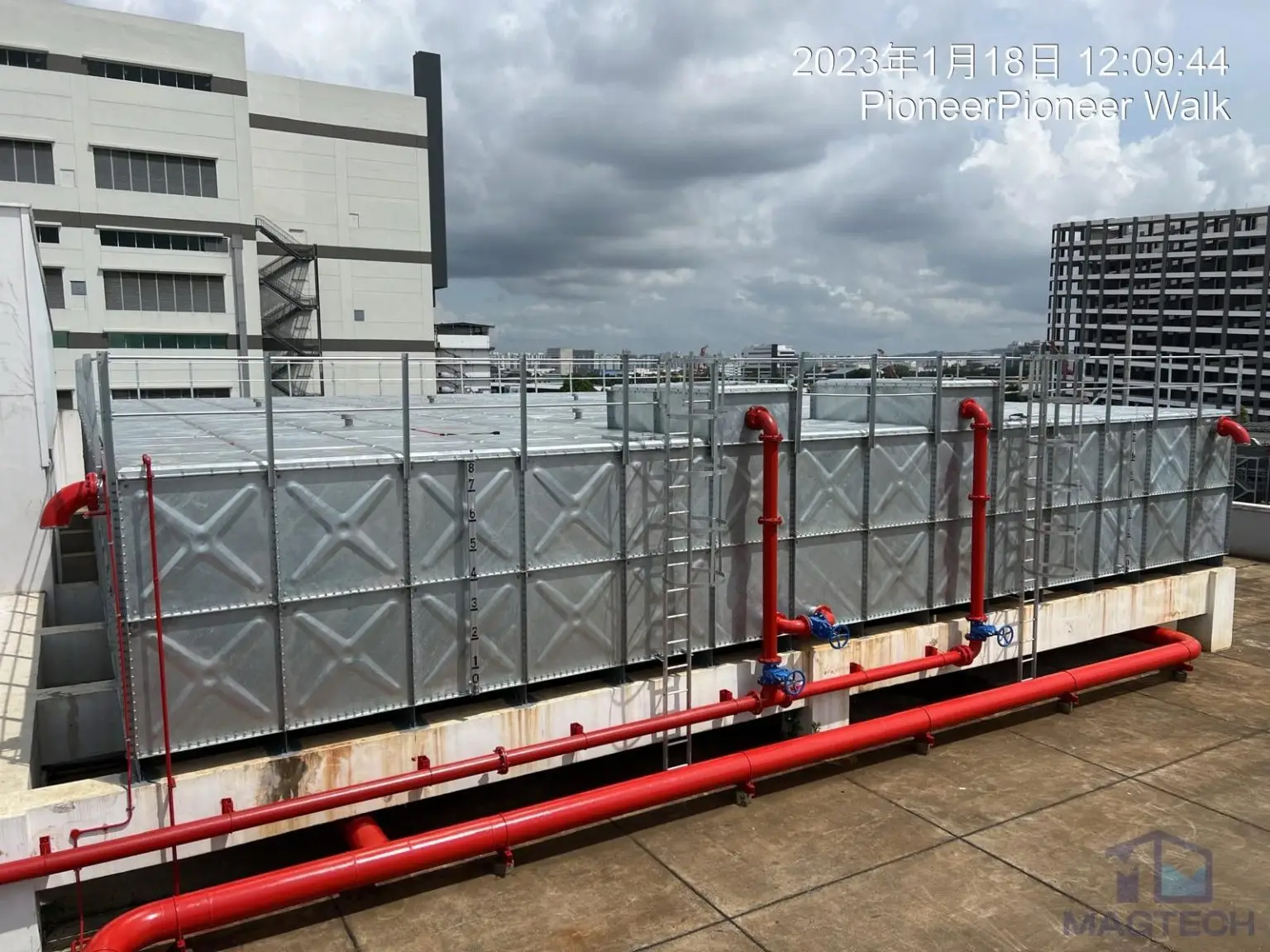 HDG sprinkler water tank replacement at 2 Pioneer Walk, Singapore – rooftop view of the completed tank with pipe connections and safety guardrails