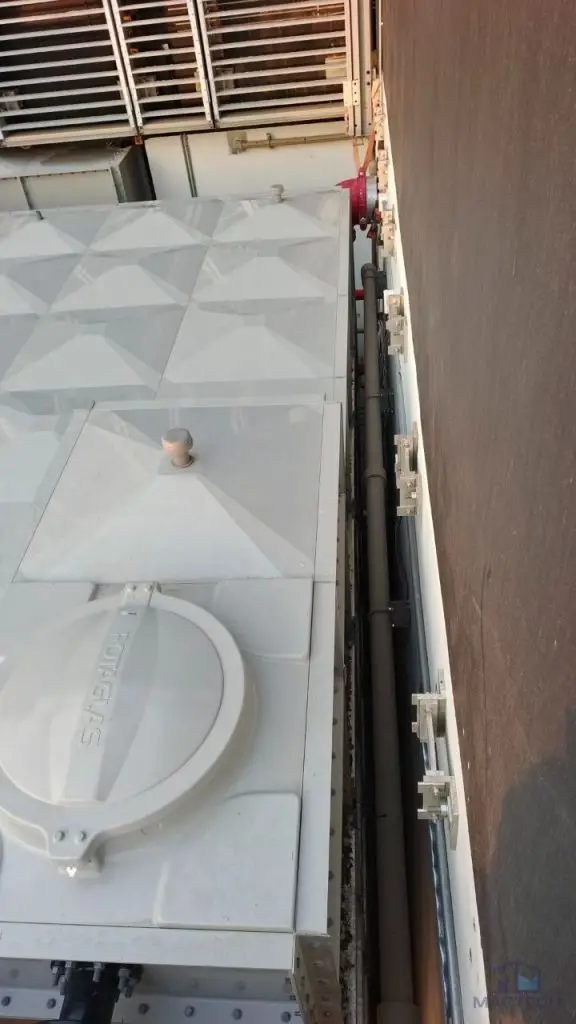 FRP/GRP water tank installation at Norodom Business Centre, Cambodia – roof panels installed beside the building wall