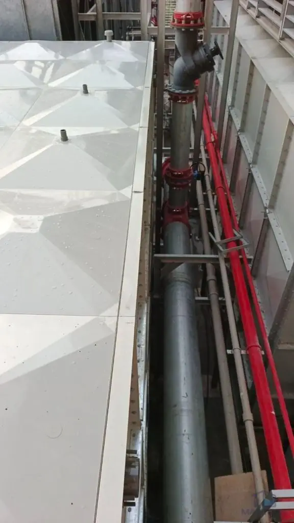 FRP/GRP water tank installation at Norodom Business Centre, Cambodia – narrow access space beside the tank and pipework