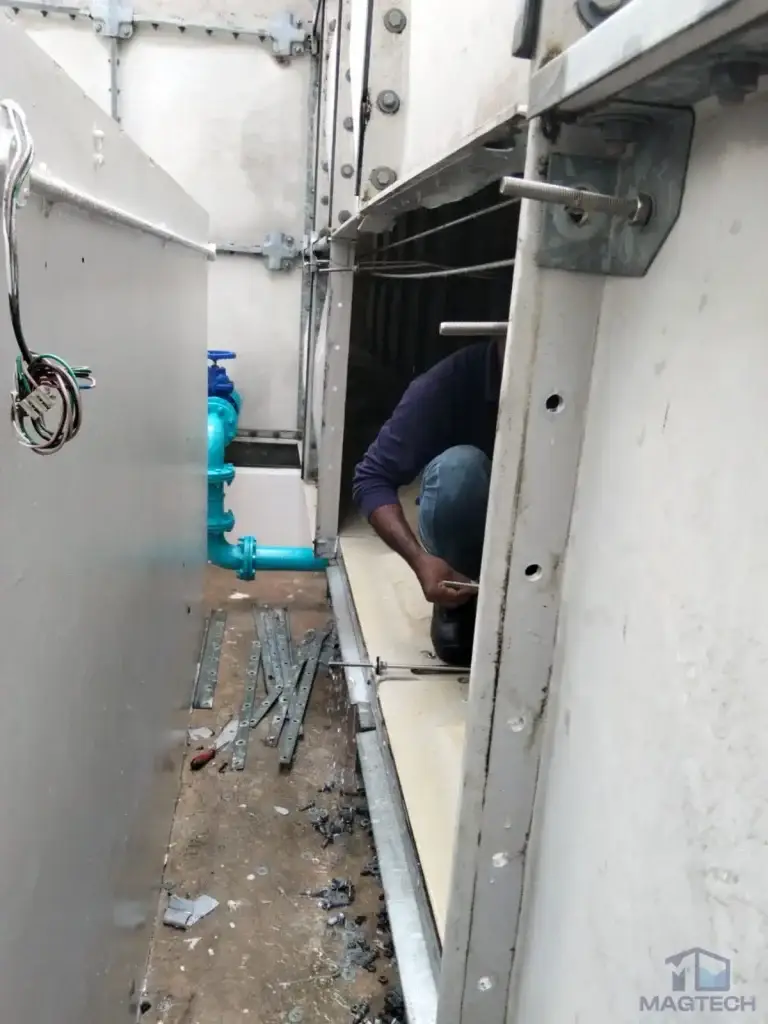 FRP sectional water tank repair at Southbank, Singapore – technician carrying out rectification work beside the tank