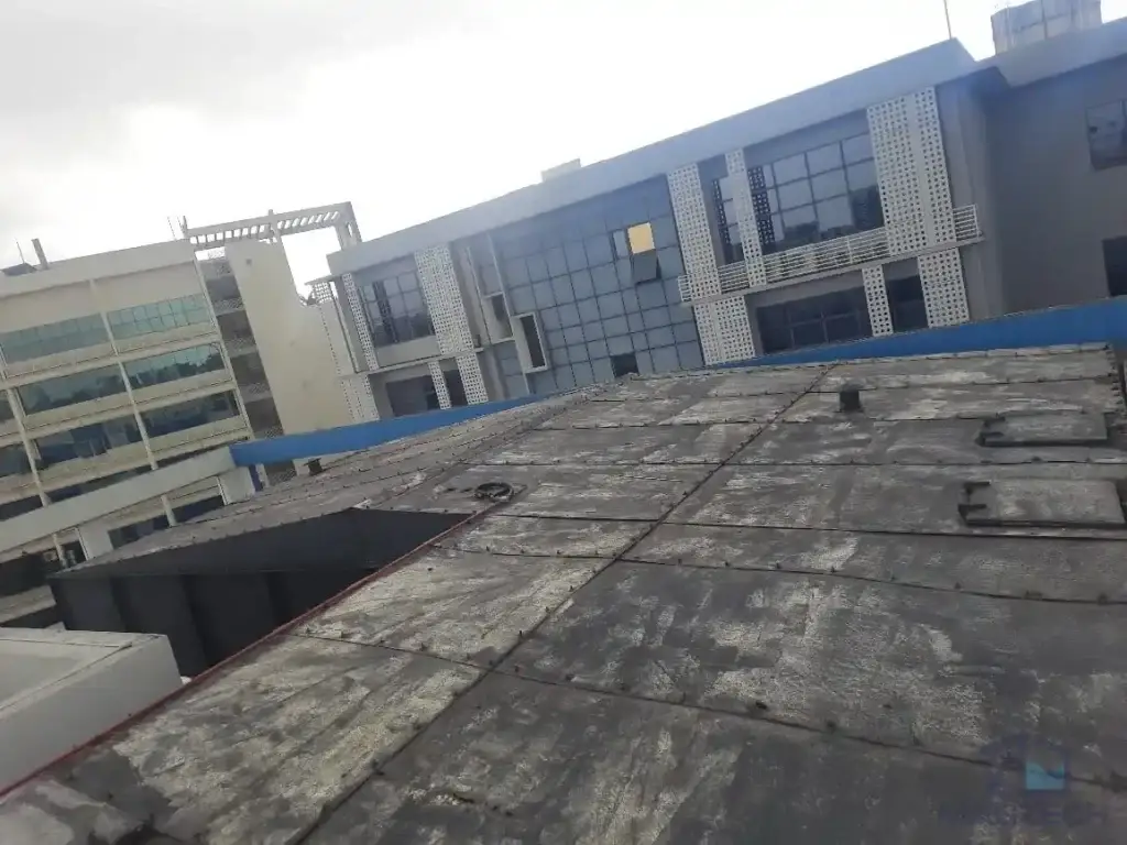 Water tank cover replacement and structural roof support renewal at AMA Building, Singapore – damaged and weathered roof panels before renewal