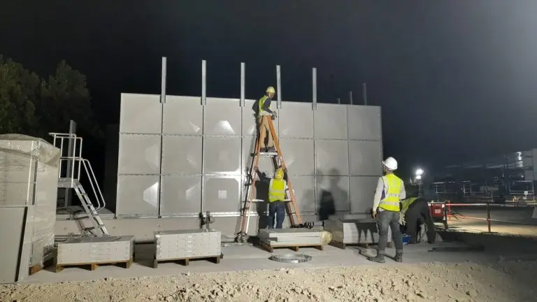 A group of workers are working together to install or replace a water tank - water tank replacement cost Singapore