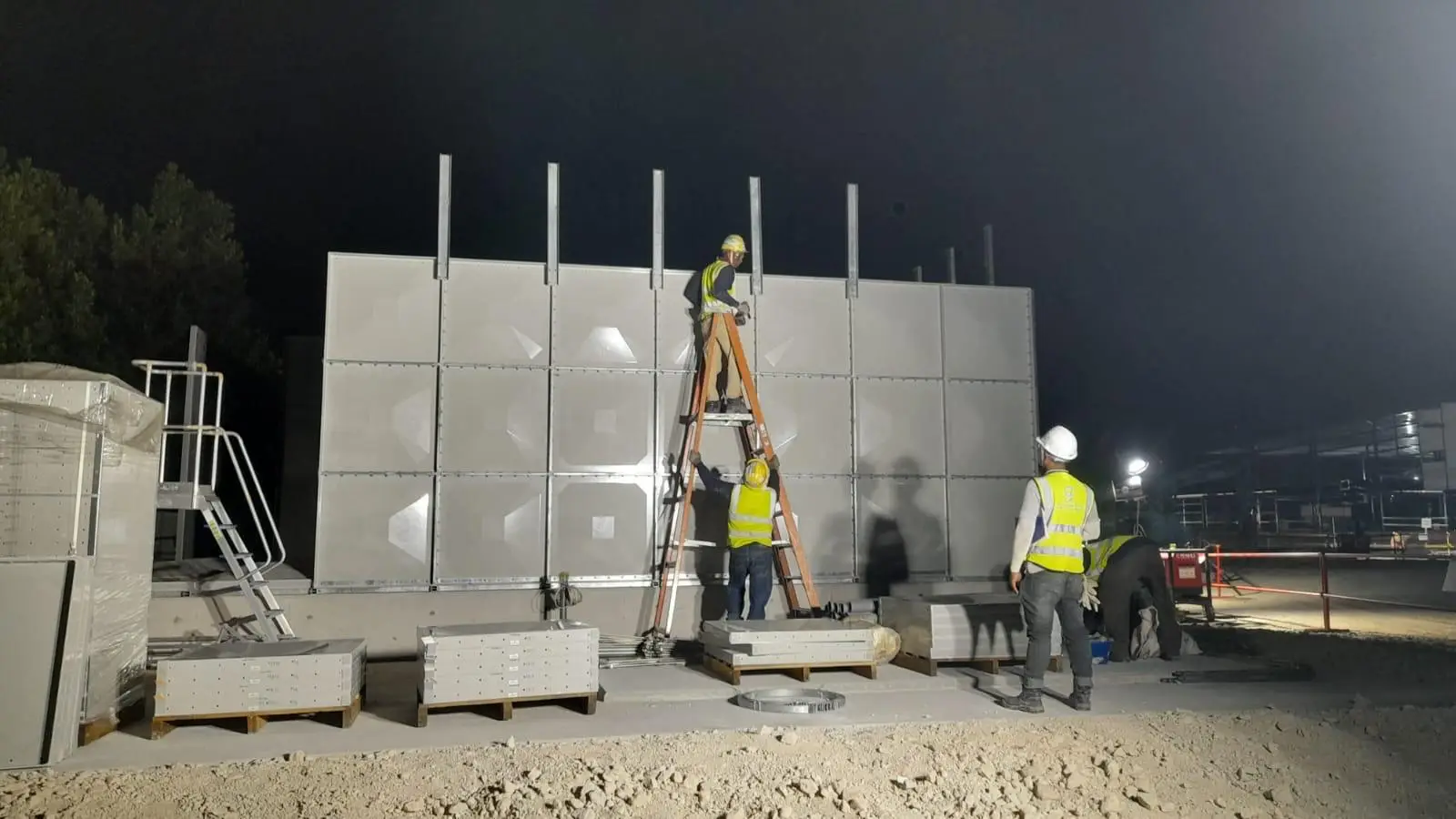 A group of workers are working together to install or replace a water tank - water tank replacement cost Singapore