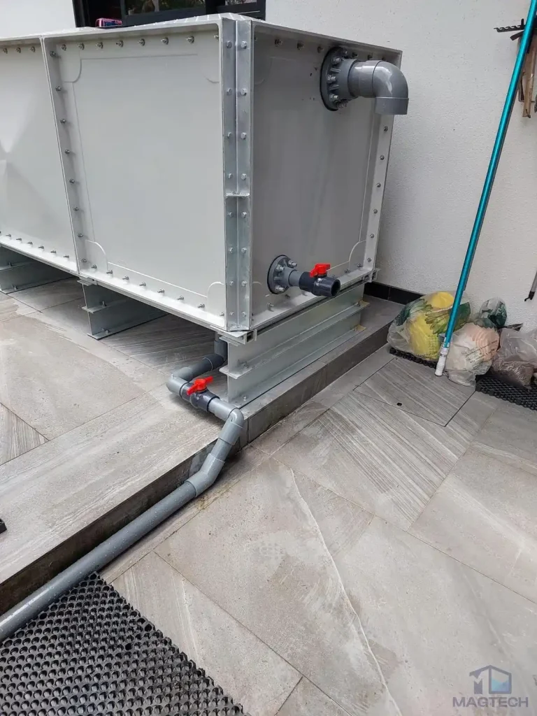 FRP rainwater tank installation at 36 Fifth Avenue, Singapore - completed tank with inlet, outlet pipes and isolation valves